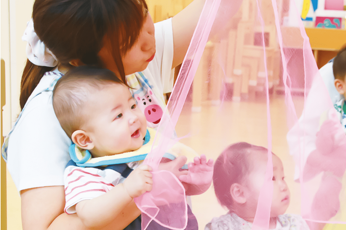 リトミックで先生が2人の子どもと触れ合う写真